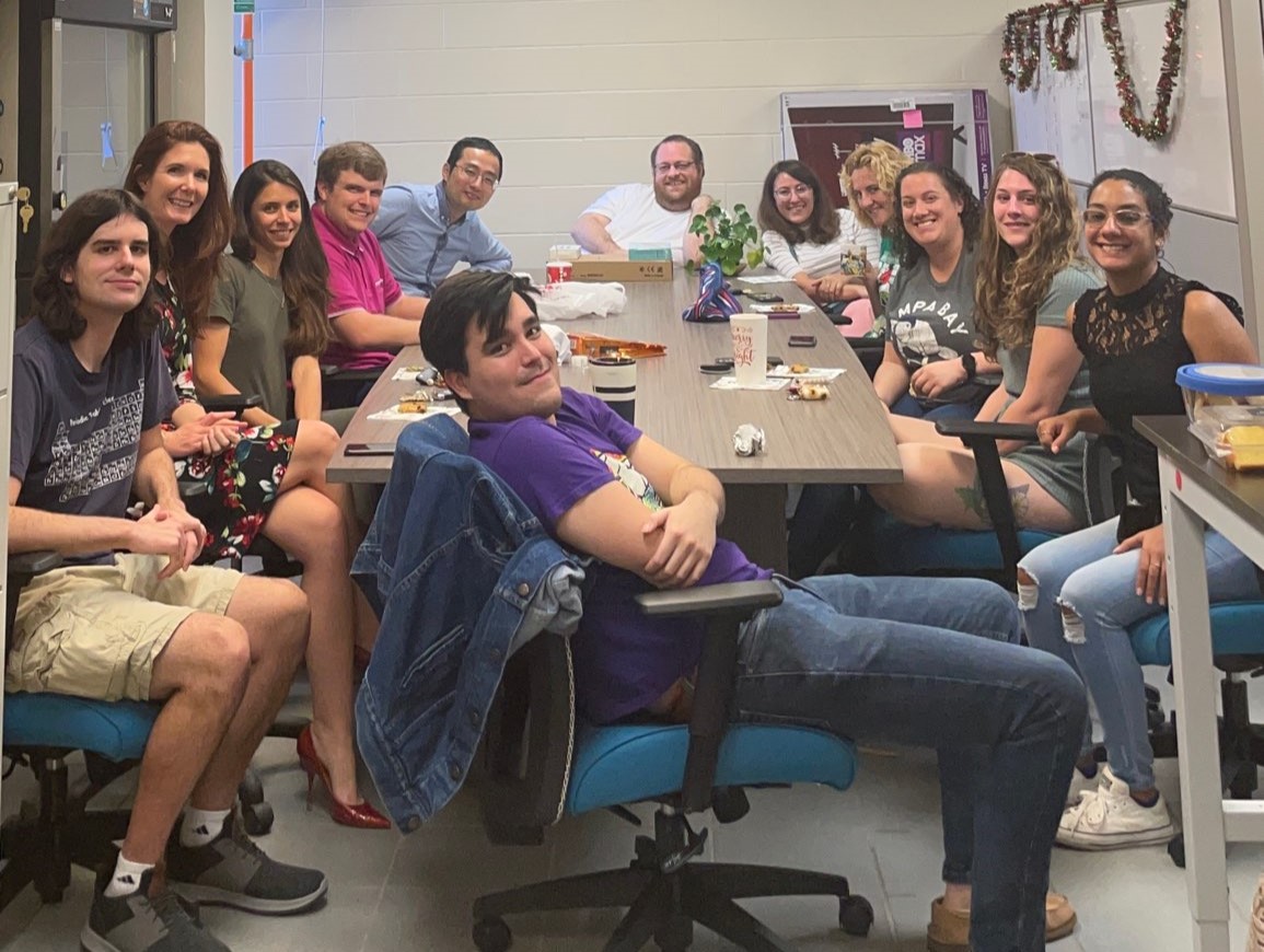 A group of people sitting around a table in an office.