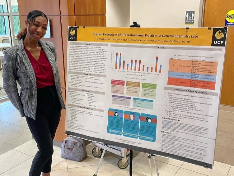 A woman standing in front of a poster presenting her research.