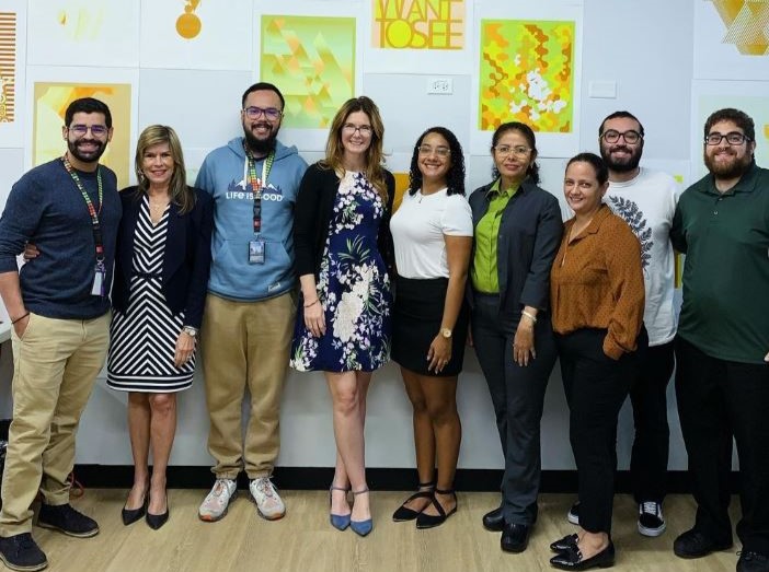 A group of people posing for a photo in front of a wall.