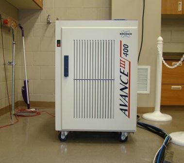 A Bruker Avance III 400 MHz spectrometer, a scientific instrument used for nuclear magnetic resonance (NMR) analysis, is situated in a laboratory.